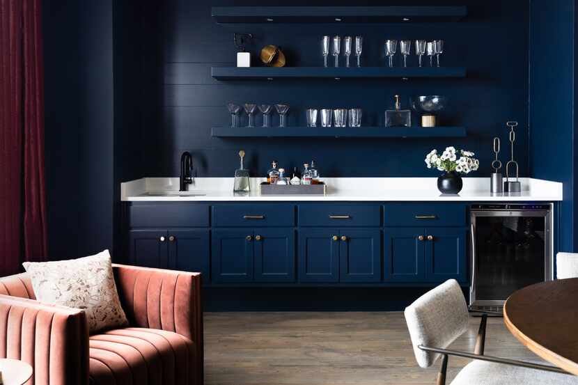 Dark blue custom bar with glassware and moody deep red curtains