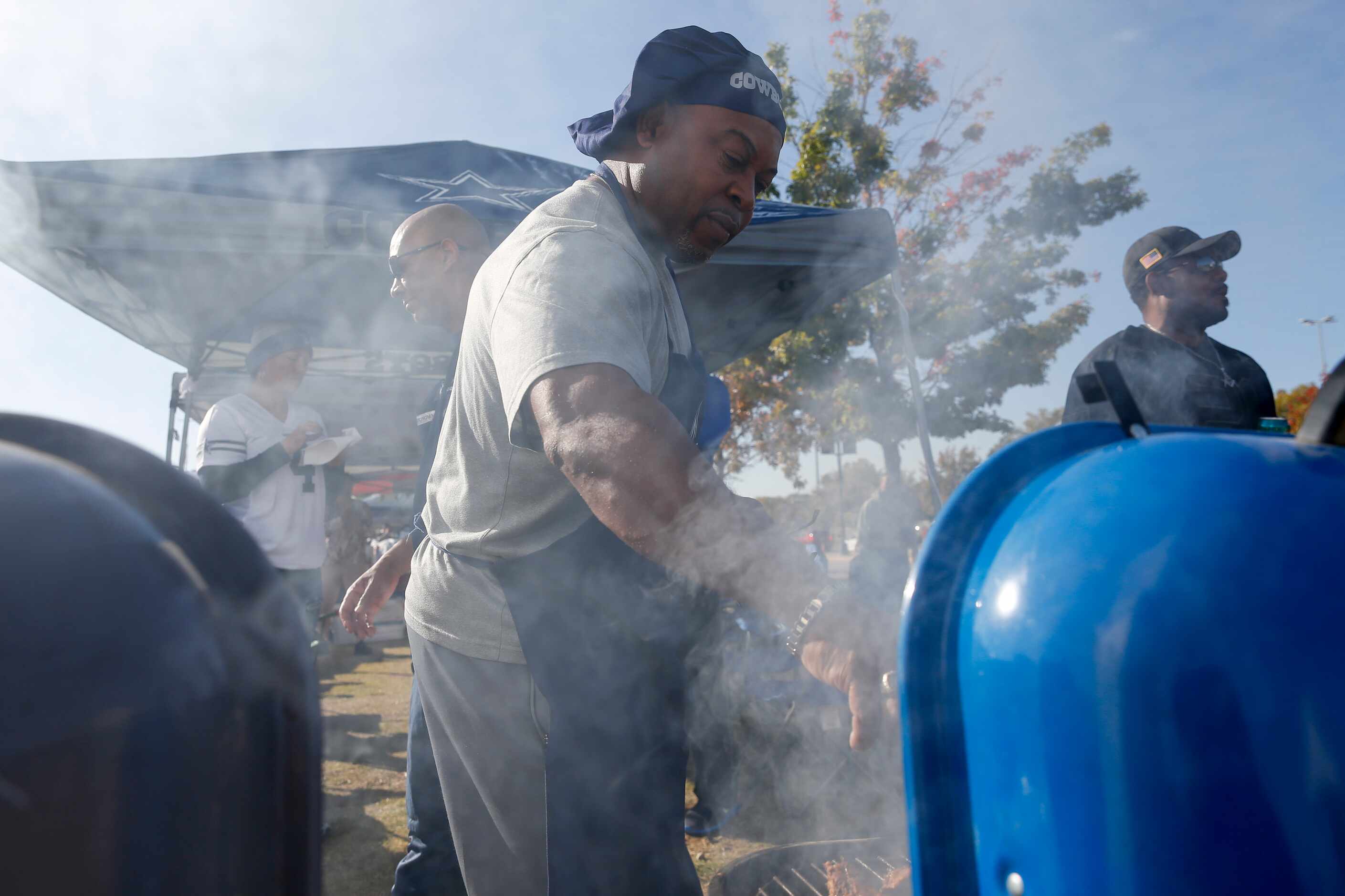 Ferdinand Shaw, 53, tends to the grill before an NFL football game between the Dallas...