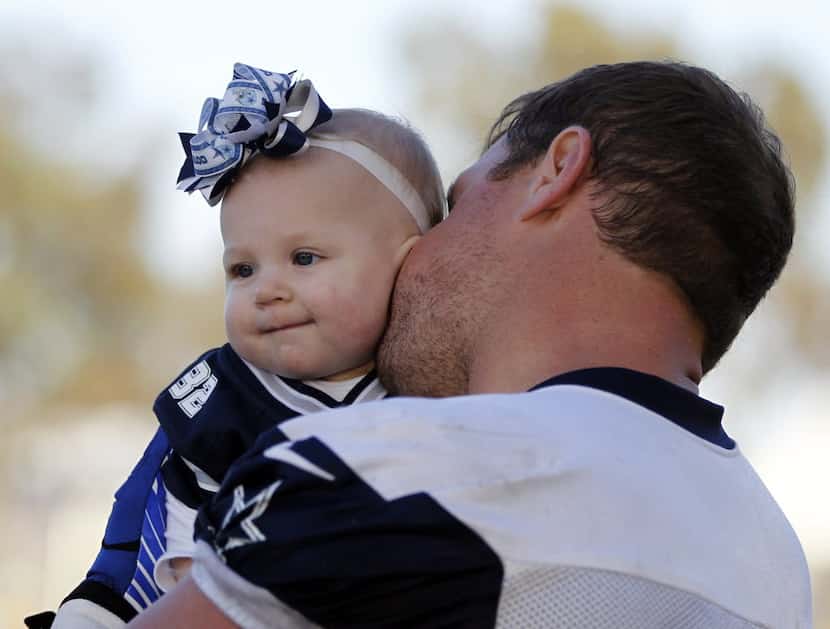Jason Witten (82) kisses his 10-month-old daughter Landry Witten after a training-camp...