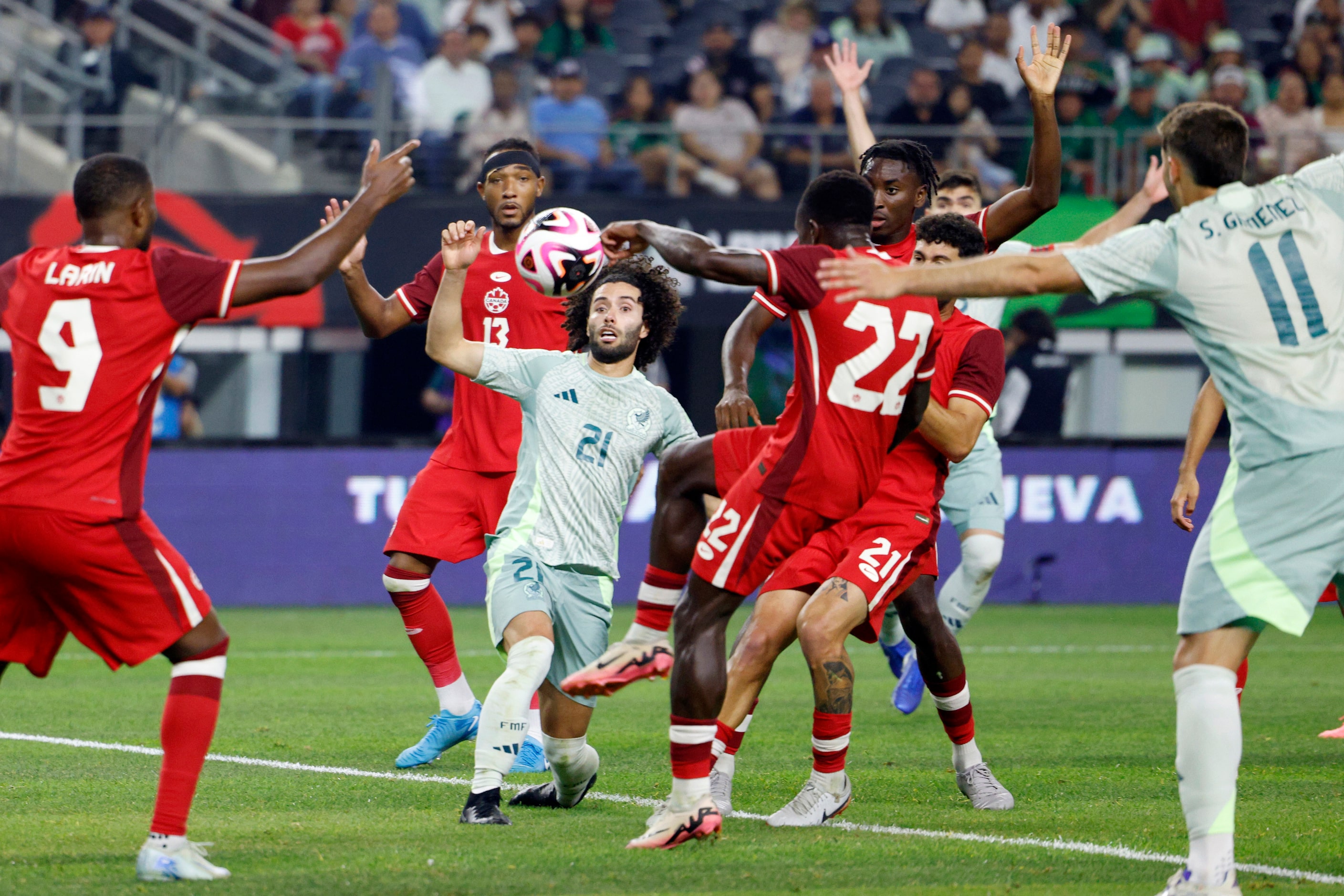 Mexico midfielder Cesar Huerta (21) battles for the ball against the Canada defense during...