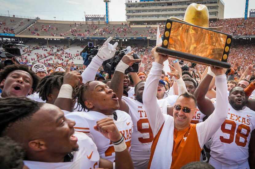 Texas head coach Steve Sarkisian lifted the Golden Hat trophy with his players after a...
