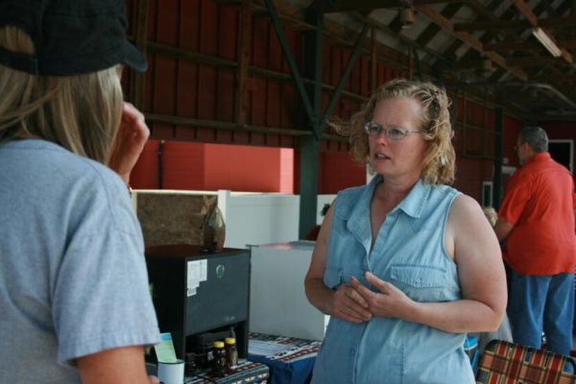 
Farm manager Christy Cox of Truthhill Farms, located in Farmersville, talks to a customer...