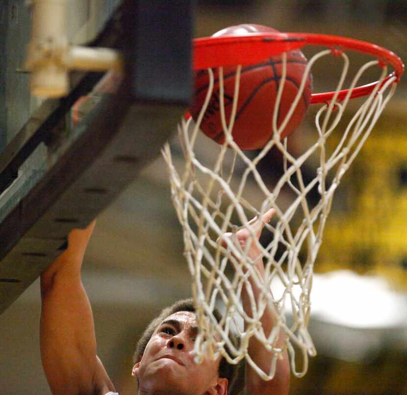 Plano West High School's D.J. Hogg (1) goes up high to lay the basketball in the basket...