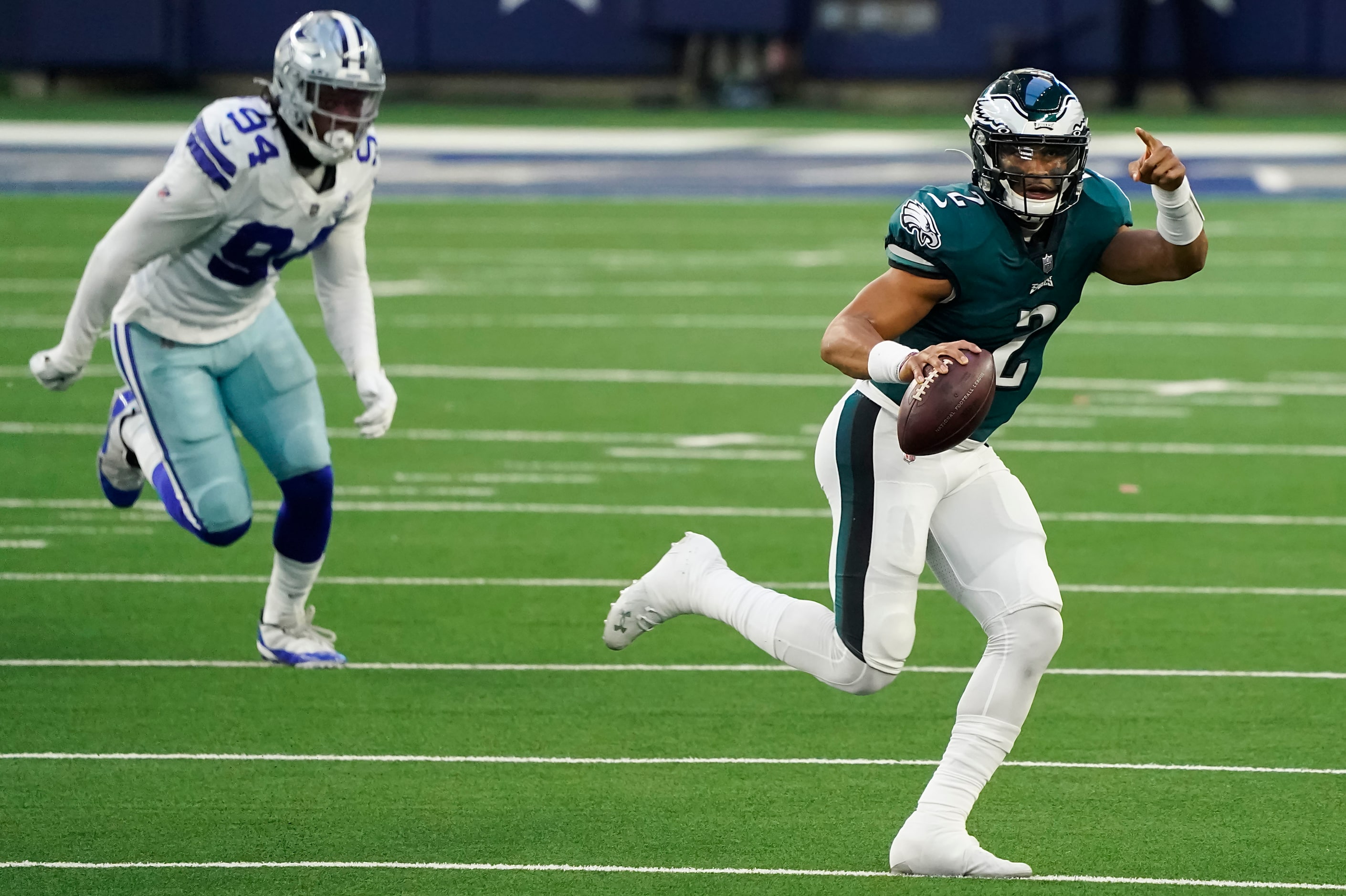 Philadelphia Eagles quarterback Jalen Hurts (2) scrambles away from the pursuit of Dallas...