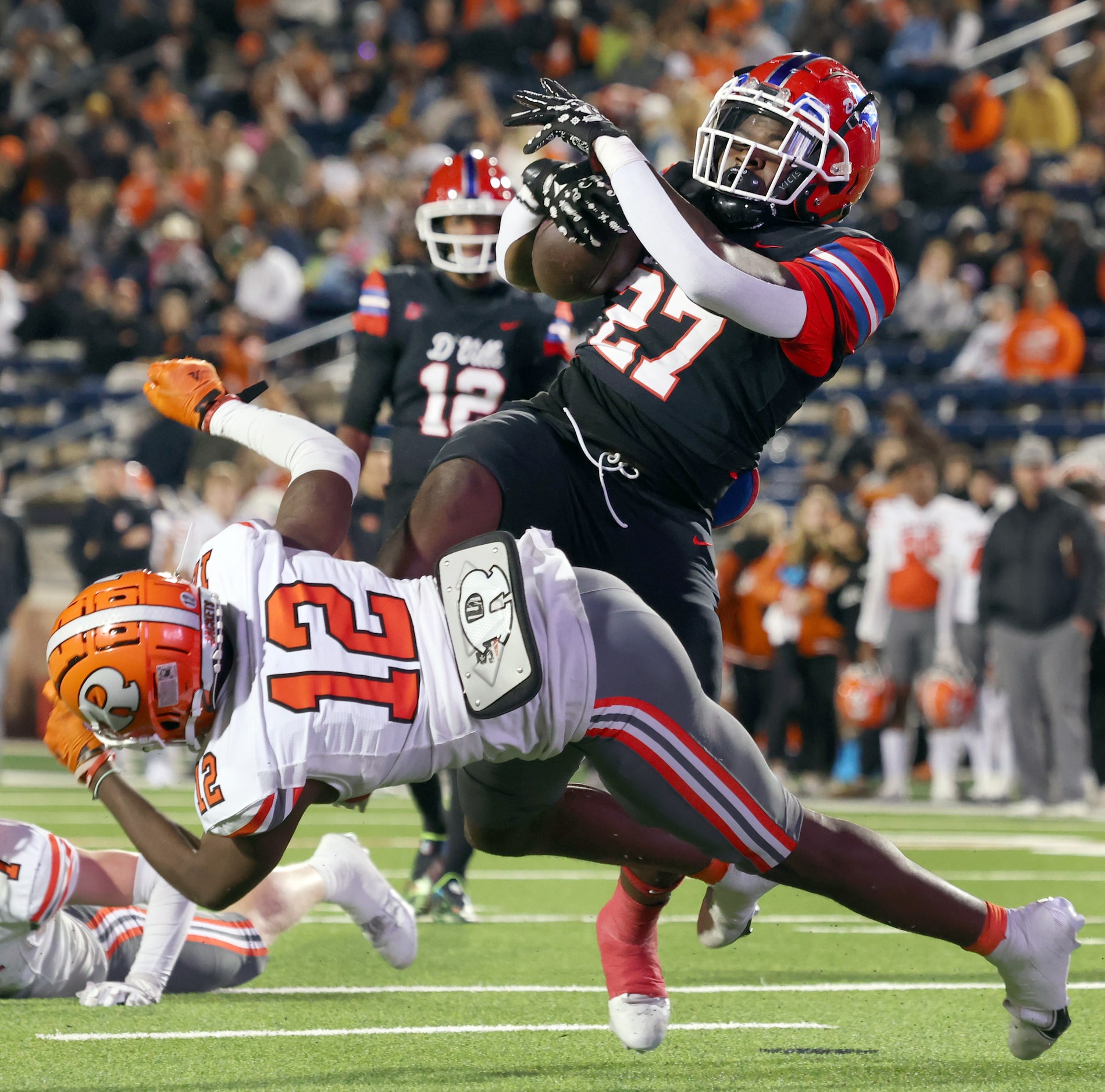 Duncanville running back JaQualon Armstrong (27), top right, bounces off from a collision...