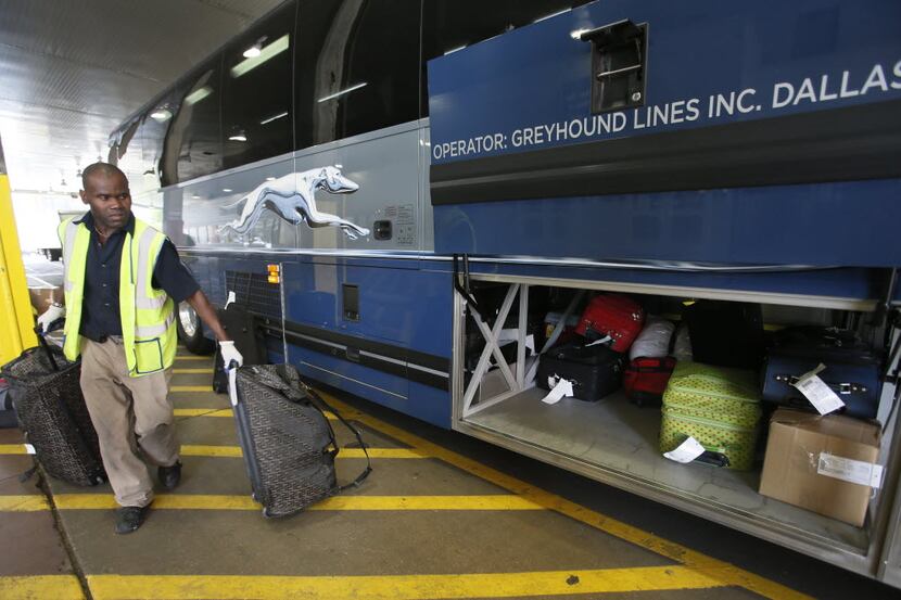 Myron Thomas loads the luggage onto a  Greyhound bus in downtown Dallas.