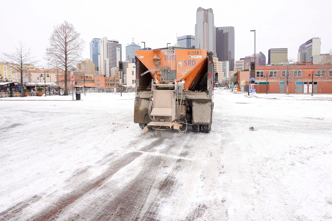 A City of Dallas Mobility and Street Services truck spreads de-icing materials downtown a...