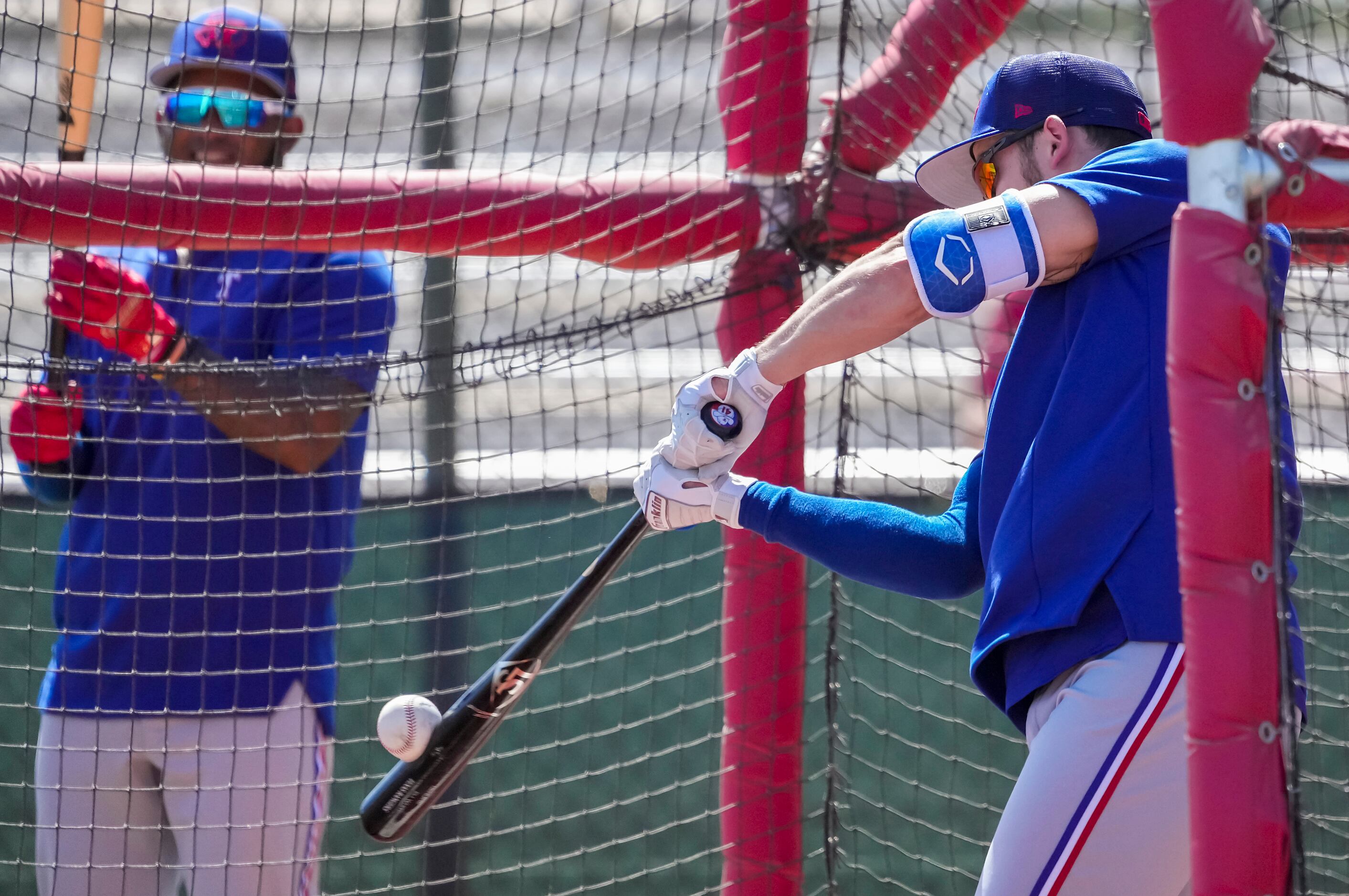Texas Rangers outfielder Eli White takes batting practice during a spring training workout...