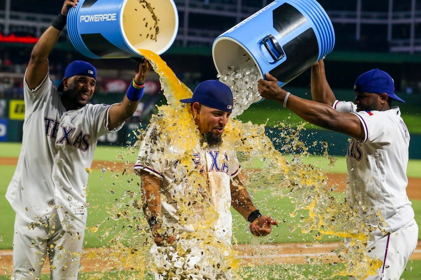 The Texas Rangers' Elvis Andrus and Hanser Alberto shower Rougned Odor after an 8-3 win...