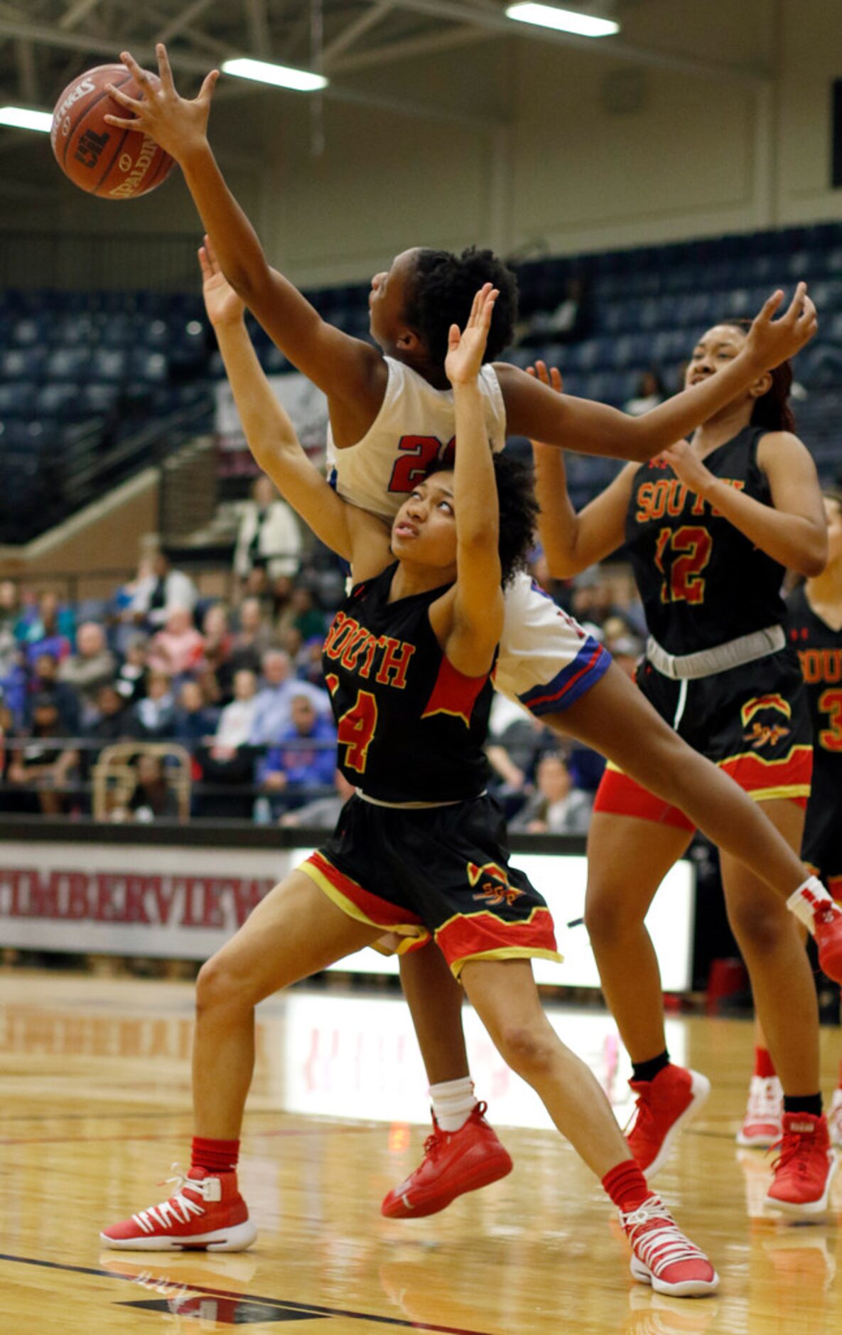 Duncanville post Anaya Bernard (20) reaches over South Grand Prairie guard Jada Handley (14)...