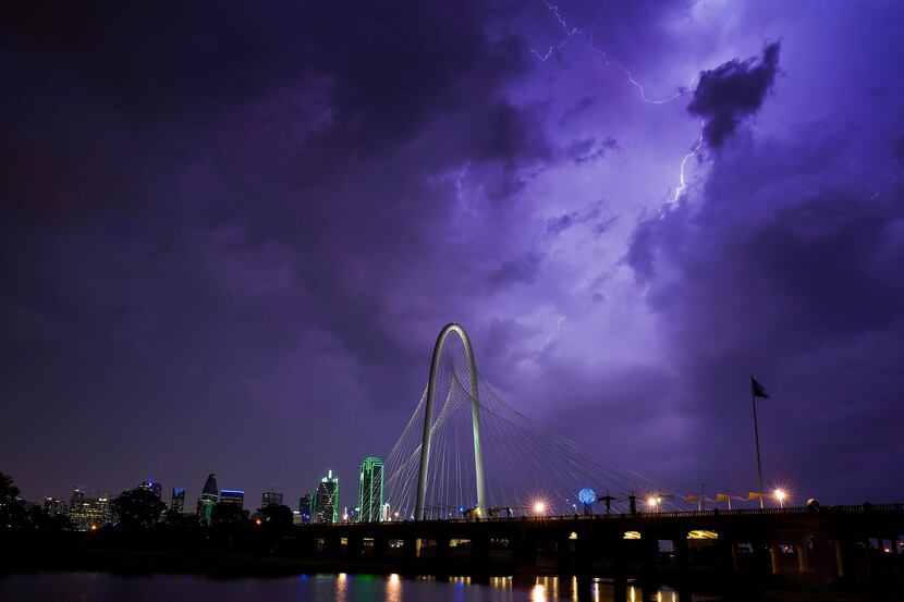 Lightning illuminates the sky over the Margaret Hunt Hill Bridge as a storm rolls over...