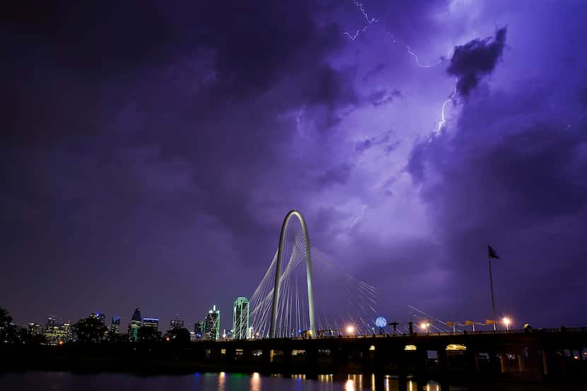 Lightning illuminates the sky over the Margaret Hunt Hill Bridge as a storm rolls over...