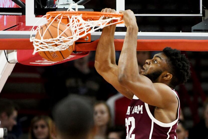 Texas A&M forward Josh Nebo (32) goes up to dunk over an Arkansas defender during the first...