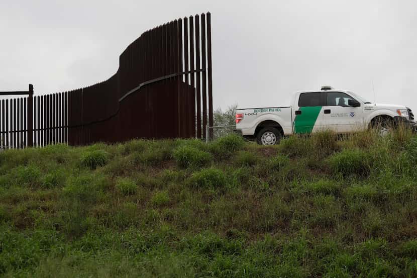 A U.S. Customs and Border Patrol agent passes along a section of border wall in Hidalgo, Texas.