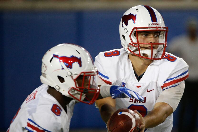 Southern Methodist Mustangs quarterback Ben Hicks (8) hands the ball off to running back...