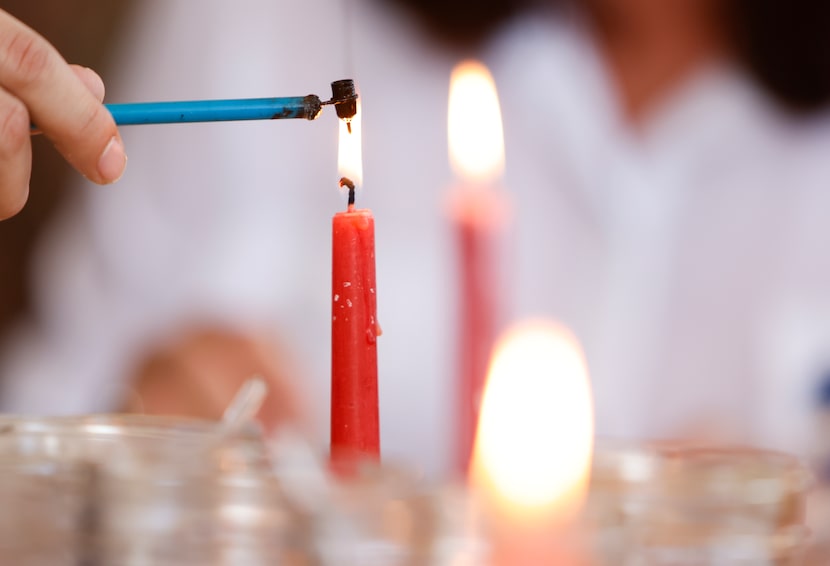 A kistka is heated with beeswax over a flame, Saturday, April, 2, 2022 in Little Elm, Texas....