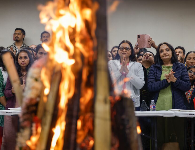 Hindu devotees pray as they perform Holika Dahan as part of the Holi festival celebrations...