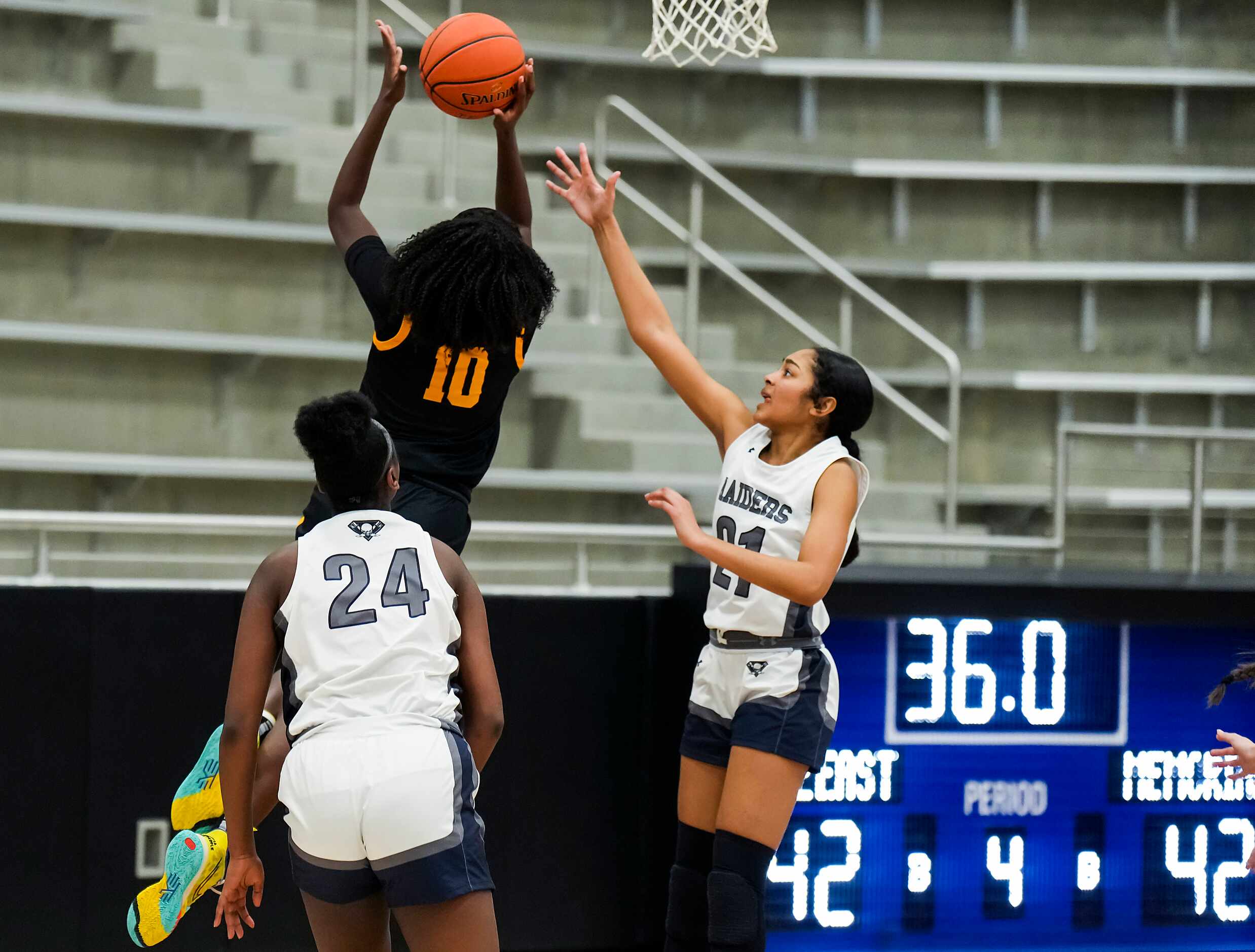 Frisco Memorial's Jasmyn Lott (10) score past Wylie East's Aleena Dawkins (21) and LeAire...