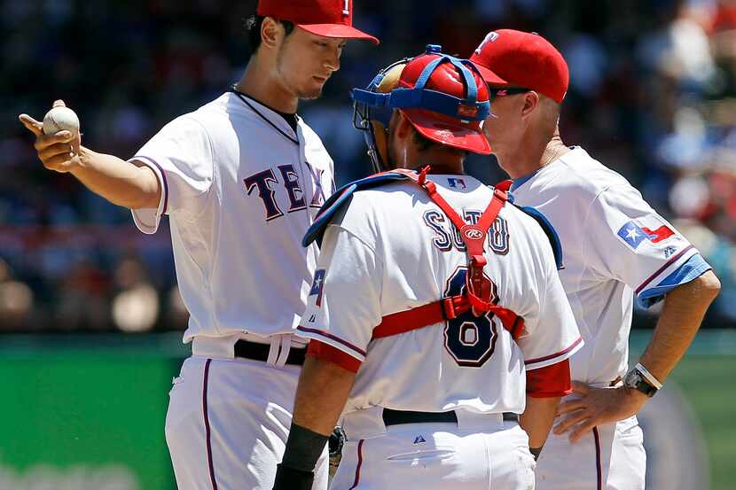 Texas Rangers pitching coach Mike Maddux (31) and catcher Geovany Soto (8) visit with...