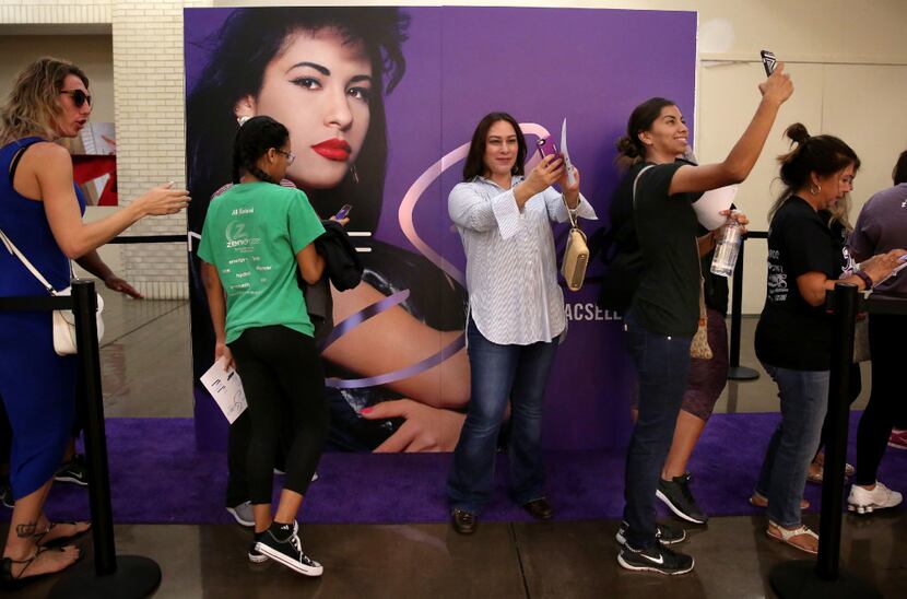 Fans take selfies and wait in line for the MAC Selena collection outside the MAC Cosmetics...