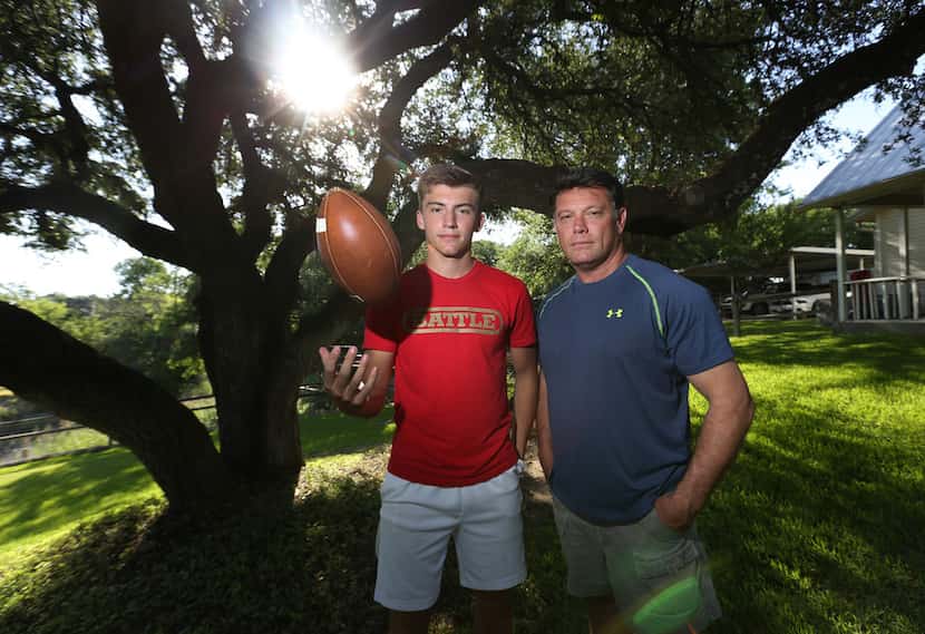 High school quarterback Ken Seals and his father Robert Seals pose in the backyard at their...