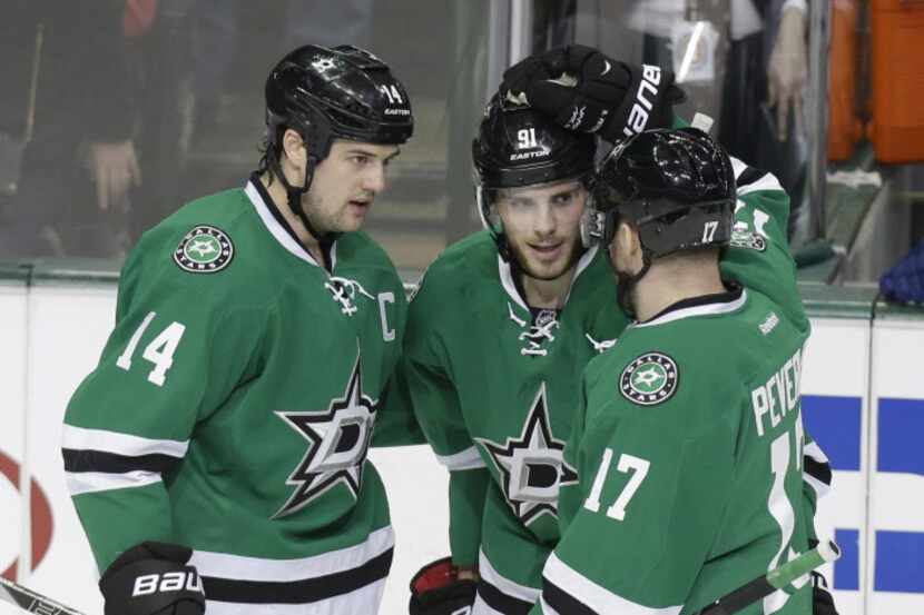 Dallas Stars Tyler Seguin, center, is congratulated by teammates Jamie Benn (14) and Rich...