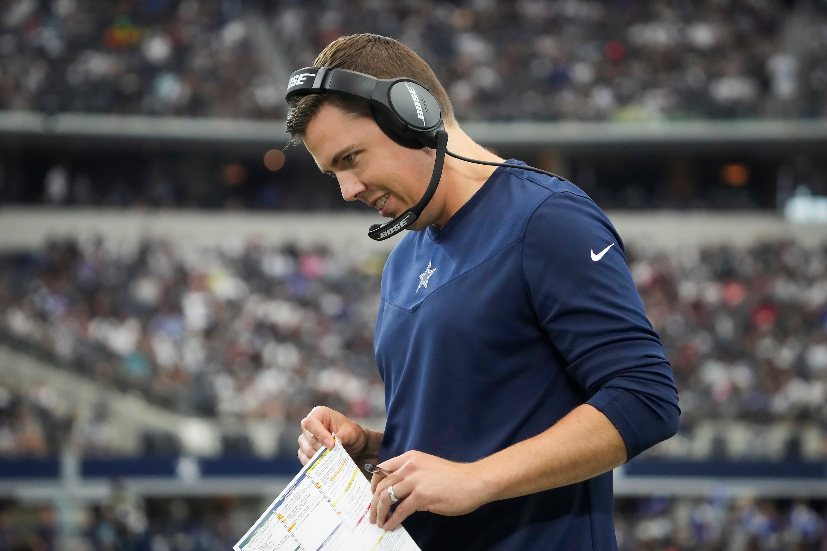 Dallas Cowboys offensive coordinator Kellen Moore works on the sidelines during the second...