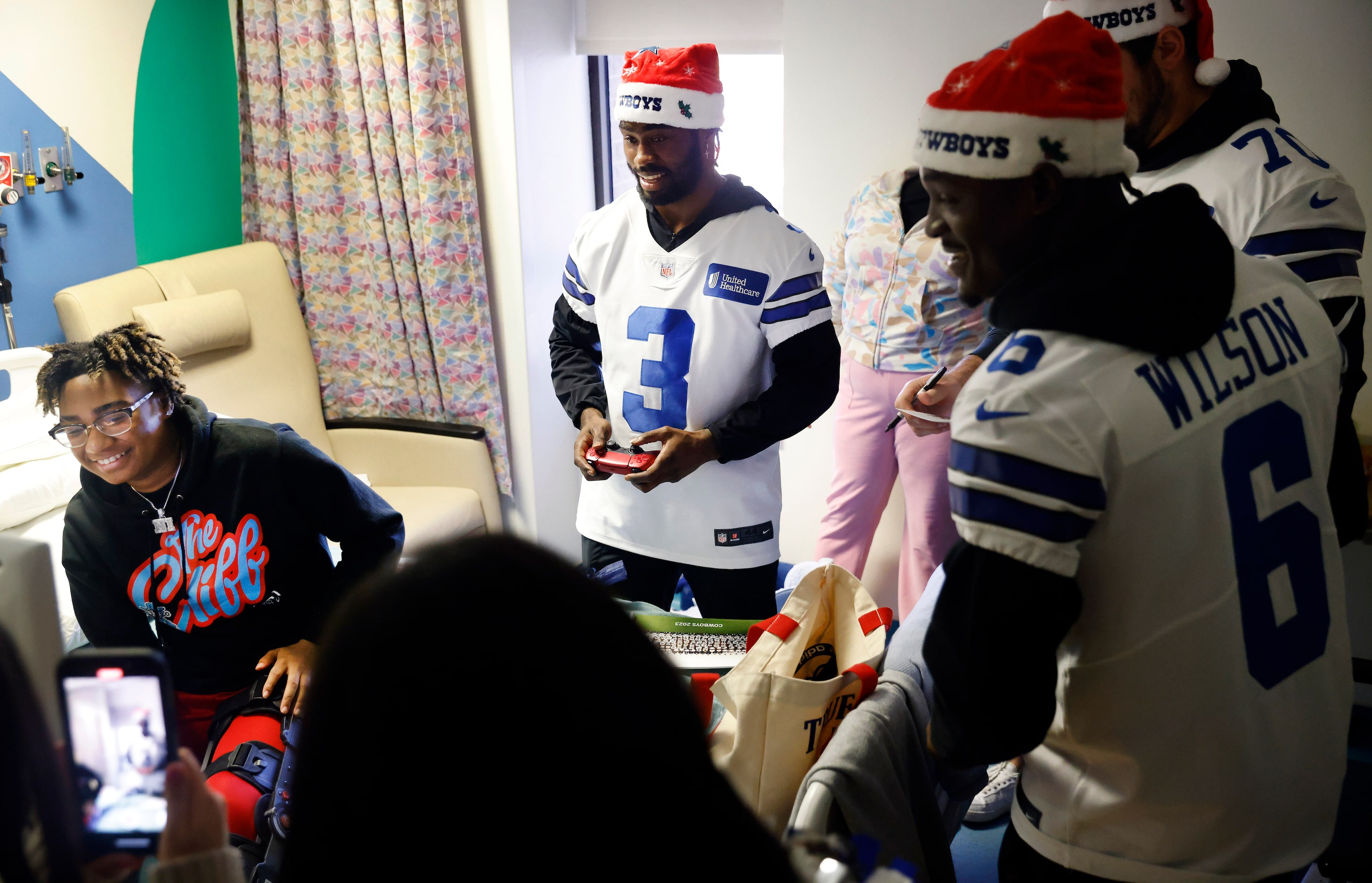 Dallas Cowboys wide receiver Brandin Cooks (3) plays NBA2K video game with patient Aniya...