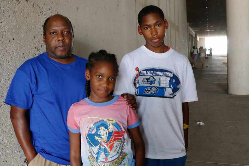 Stacey Stewart poses with his children, Destiny, 10,  center, and JaâCobie, 14, by the KBH...