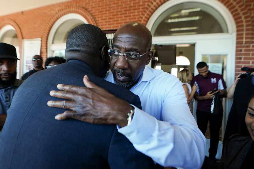 Democratic nominee for U.S Senate Sen. Raphael Warnock embraces a supporter during a...