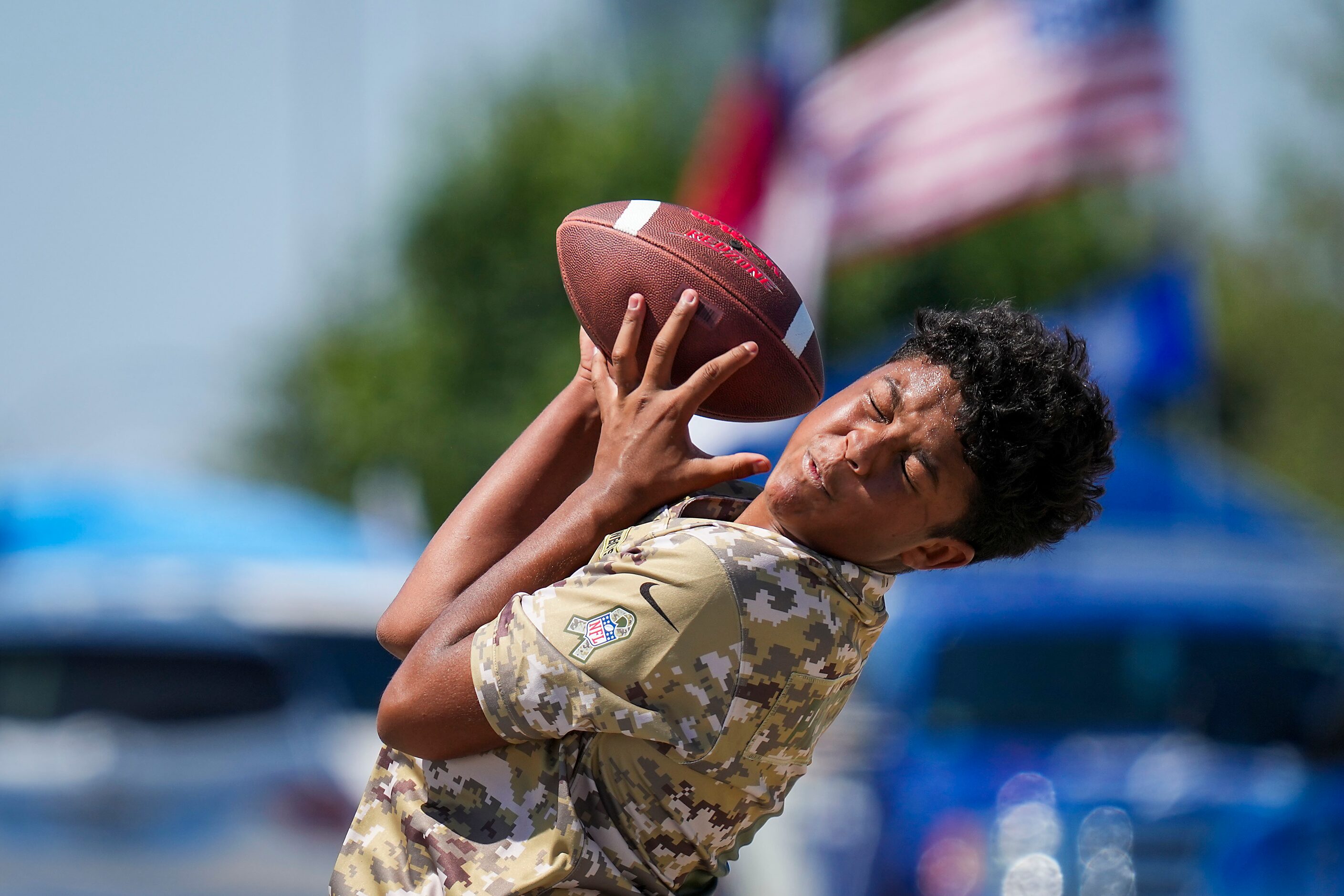 Dominik Cooper,12, catches a football while tailgating before an NFL football game at AT&T...