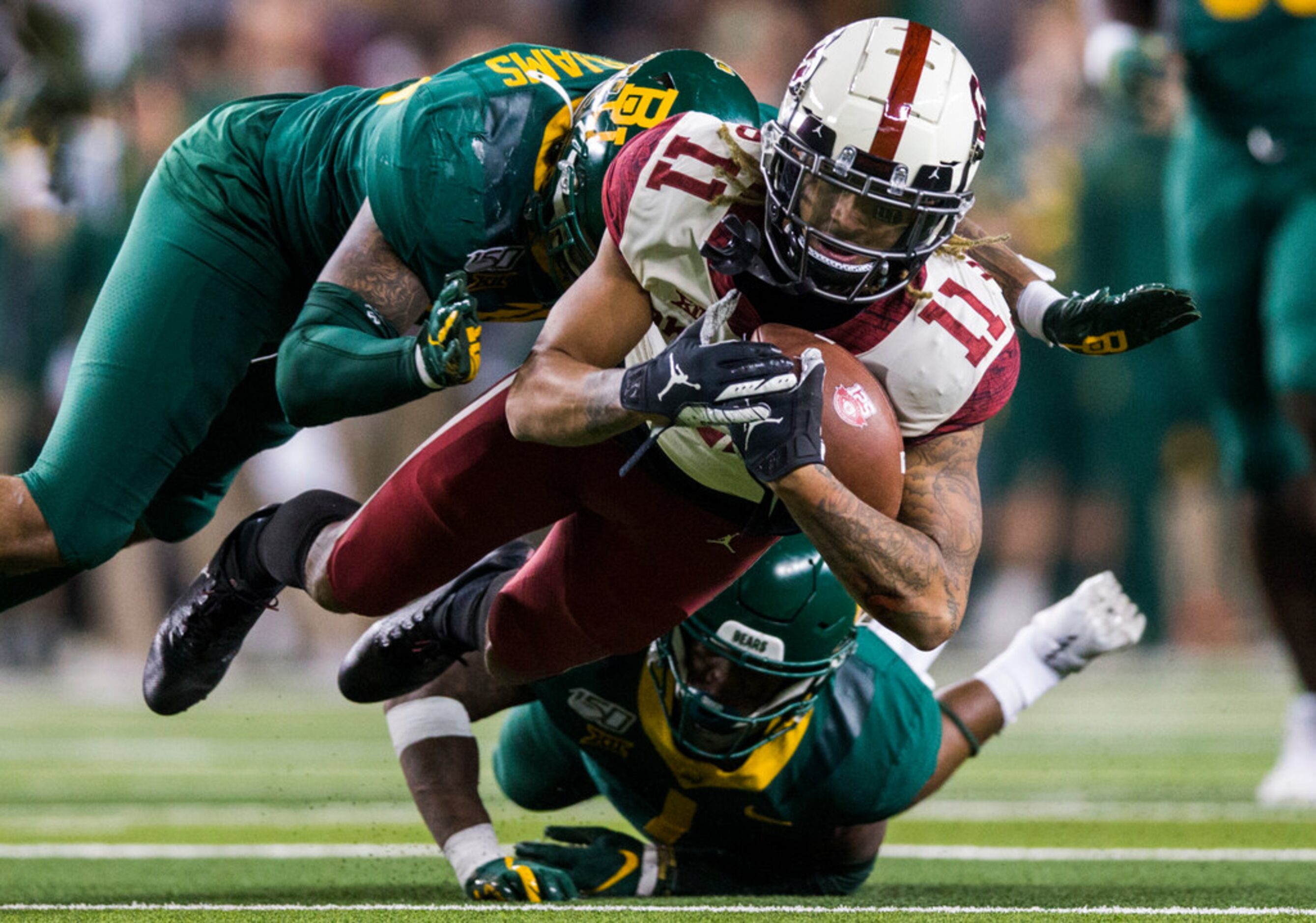 Oklahoma Sooners wide receiver Jadon Haselwood (11) is tackled by Baylor Bears cornerback...