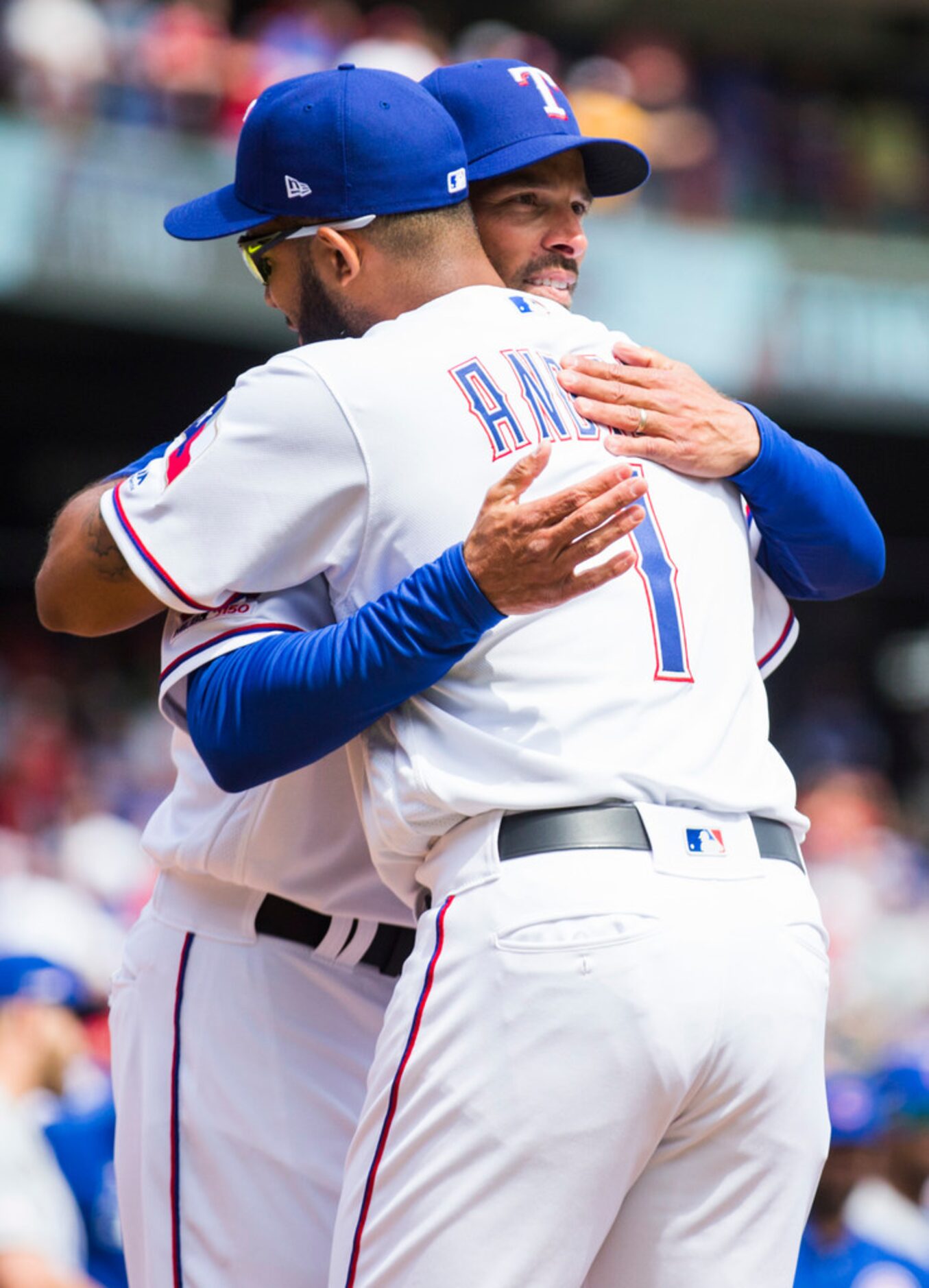 Texas Rangers manager Chris Woodward (8) hugs shortstop Elvis Andrus (1) before an opening...