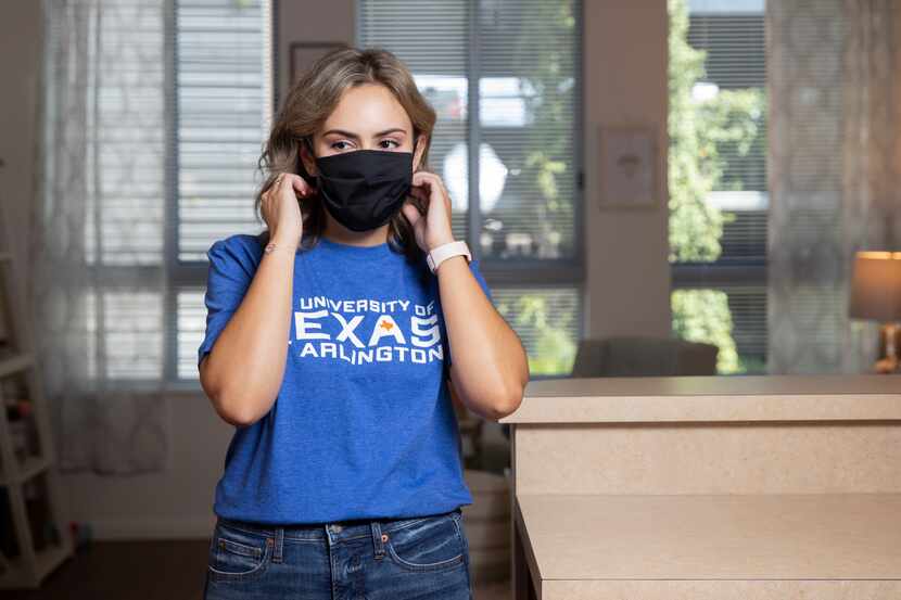 Maddie Eby, a graduate student at the University of Texas at Arlington, adjusts her mask...