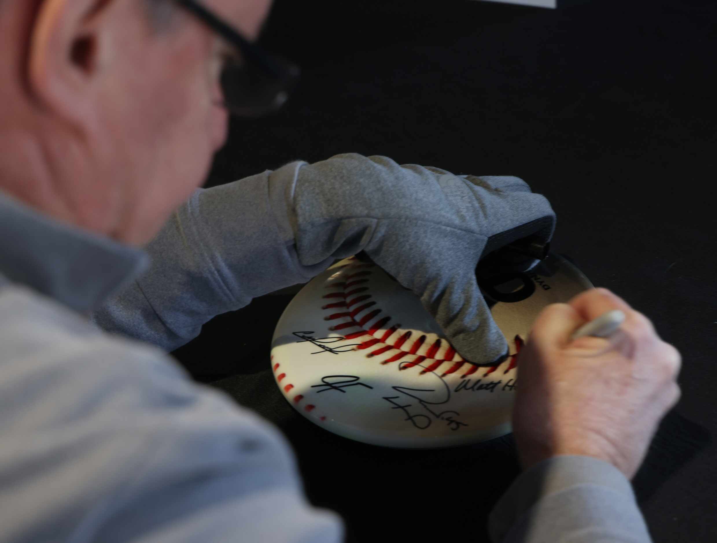 Texas Rangers radio broadcaster Matt Hicks autographs a frisbee for a fan. Rangers fans...