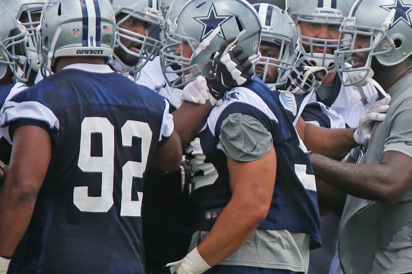 Dallas defensive end Tyrone Crawford (98), center, mixes it up with teammates near the end...