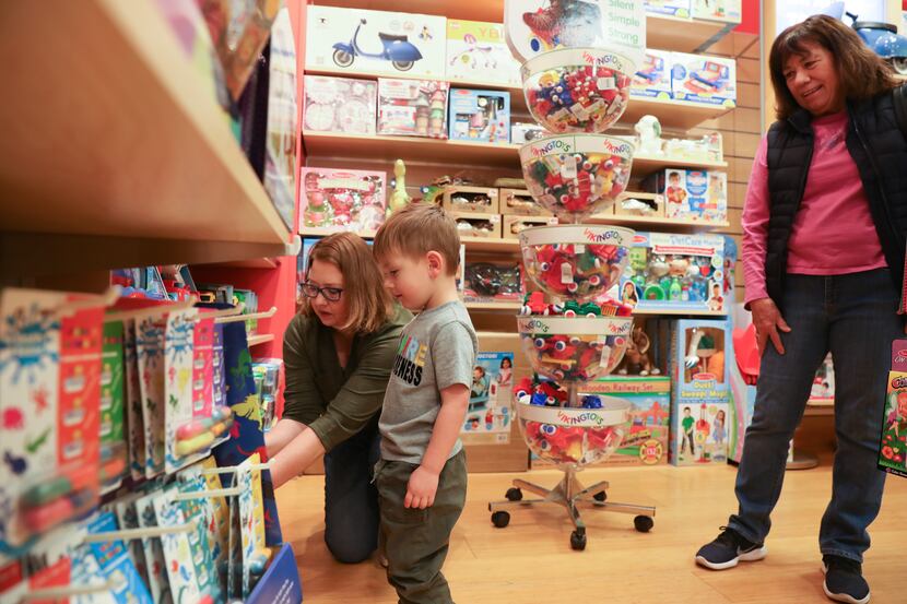 Learning Express store owner Jen Kaplinsky and visitor Asher Tinch (center), 3, play with...
