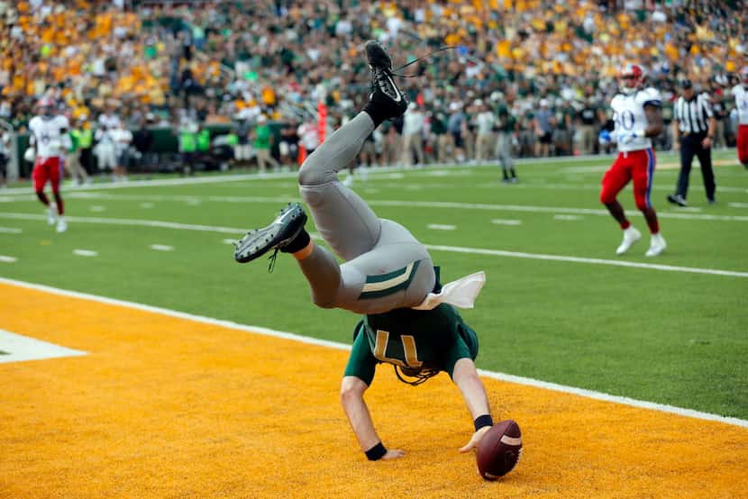 Baylor quarterback Seth Russell lands in the end zone after keeping the ball for a run and...