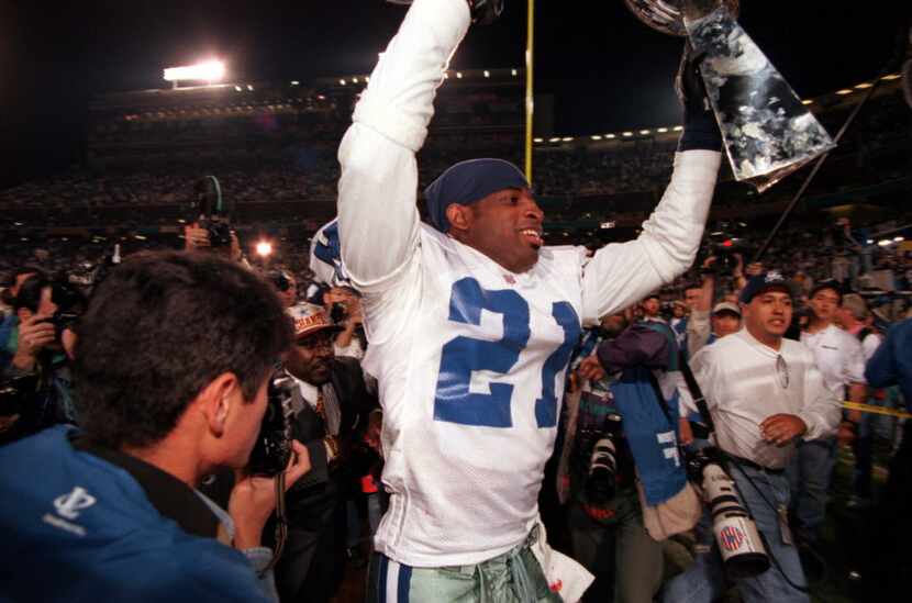Dallas Cowboys' Deion Sanders, #21,  holds the trophy up in the air after the Cowboys won...