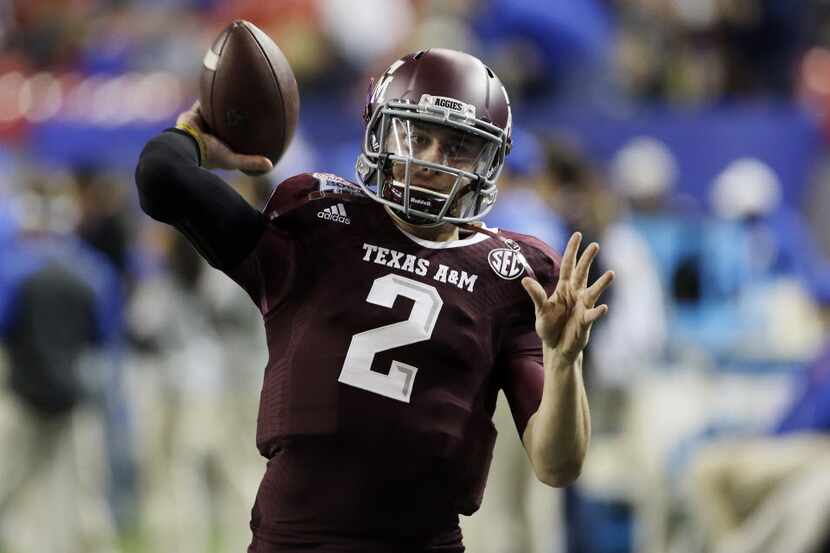 In this Dec. 31, 2013, file photo, Texas A&M quarterback Johnny Manziel (2) warms up before...