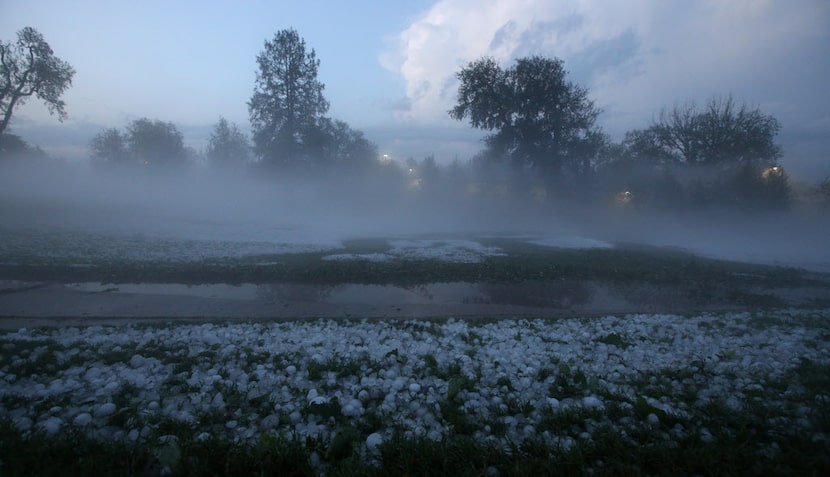  Steam rises from a coat of melting hail at Lakewood Country Club after a hailstorm hit the...