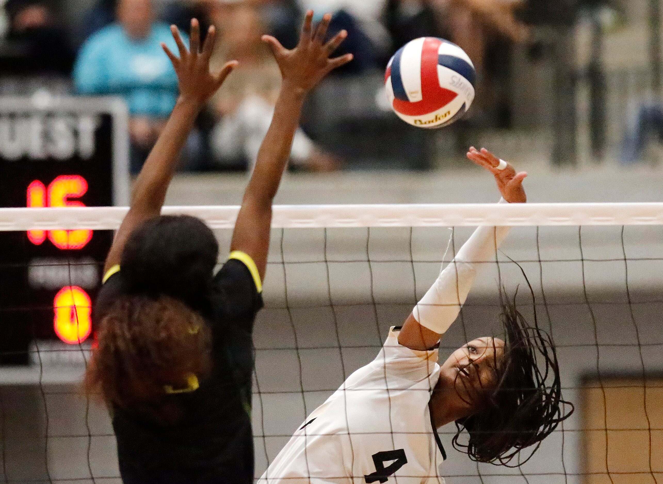 Mansfield High School outside hitter Brynn Williams (4) hits past DeSoto High School setter...