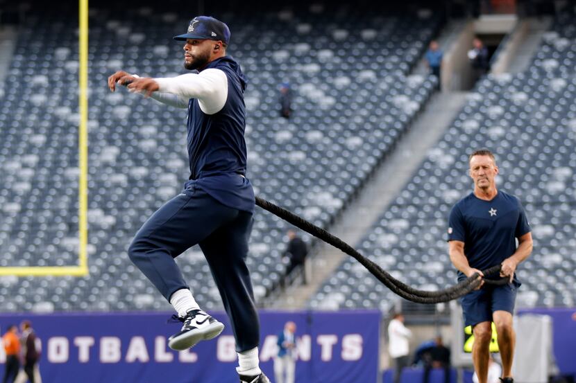Dallas Cowboys quarterback Dak Prescott exercises with a resistance band before their game...