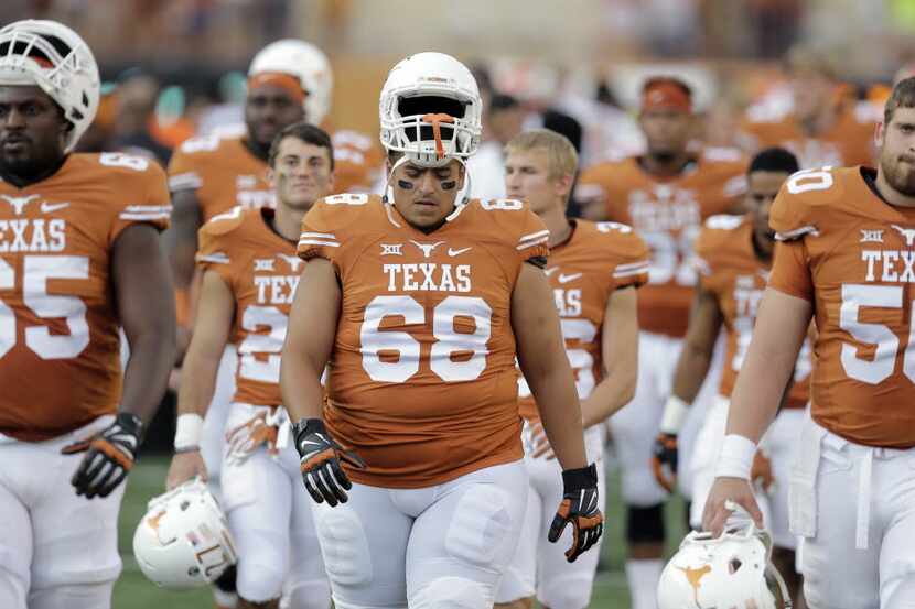 Texas players walk off the field after losing to Oklahoma State in an NCAA college football...