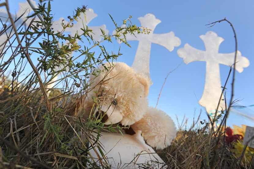 Remembrances left near the group of 26 crosses sit in the afternoon sun in Sutherland...