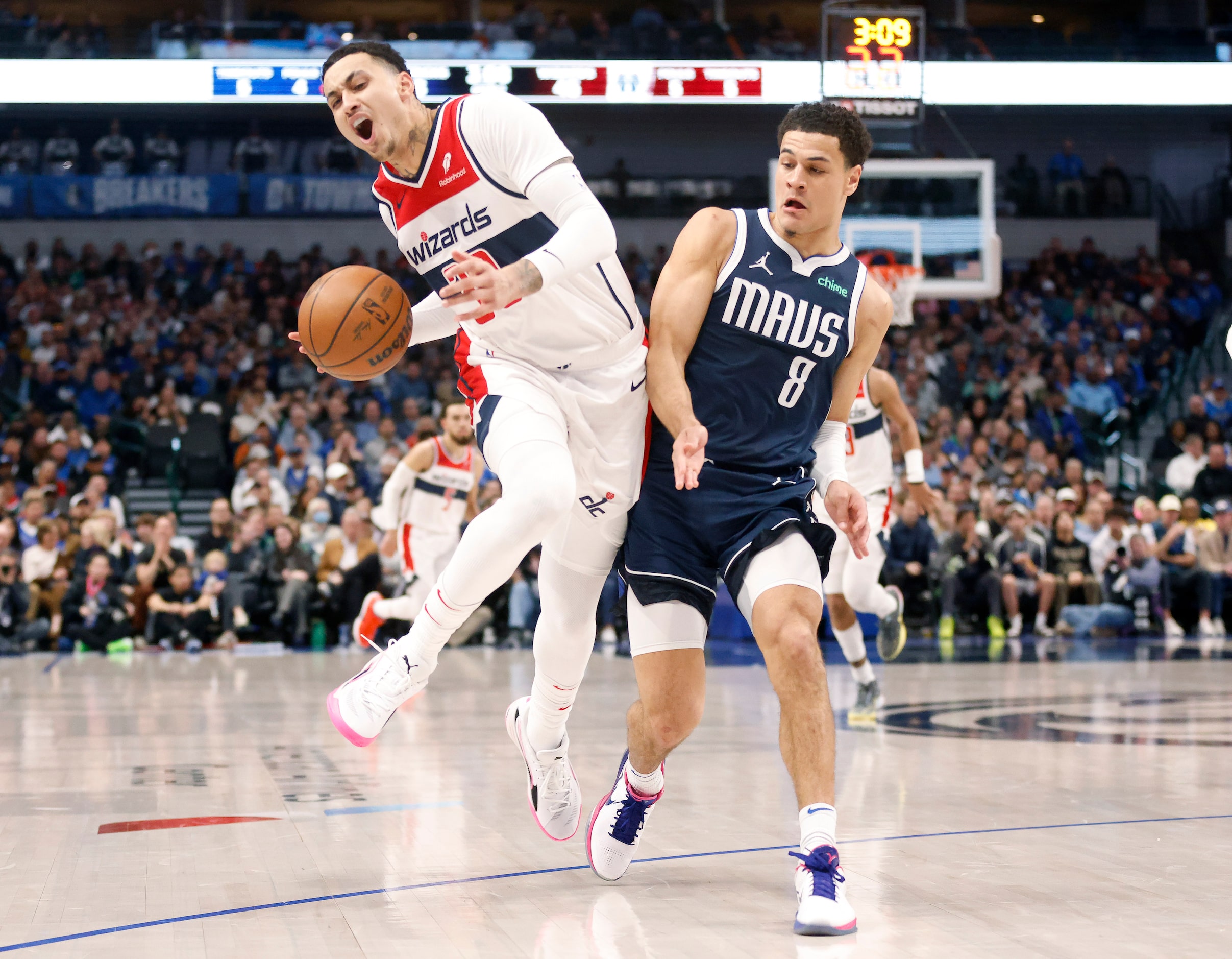 Dallas Mavericks guard Josh Green (8) bumps Washington Wizards forward Kyle Kuzma (33) as he...