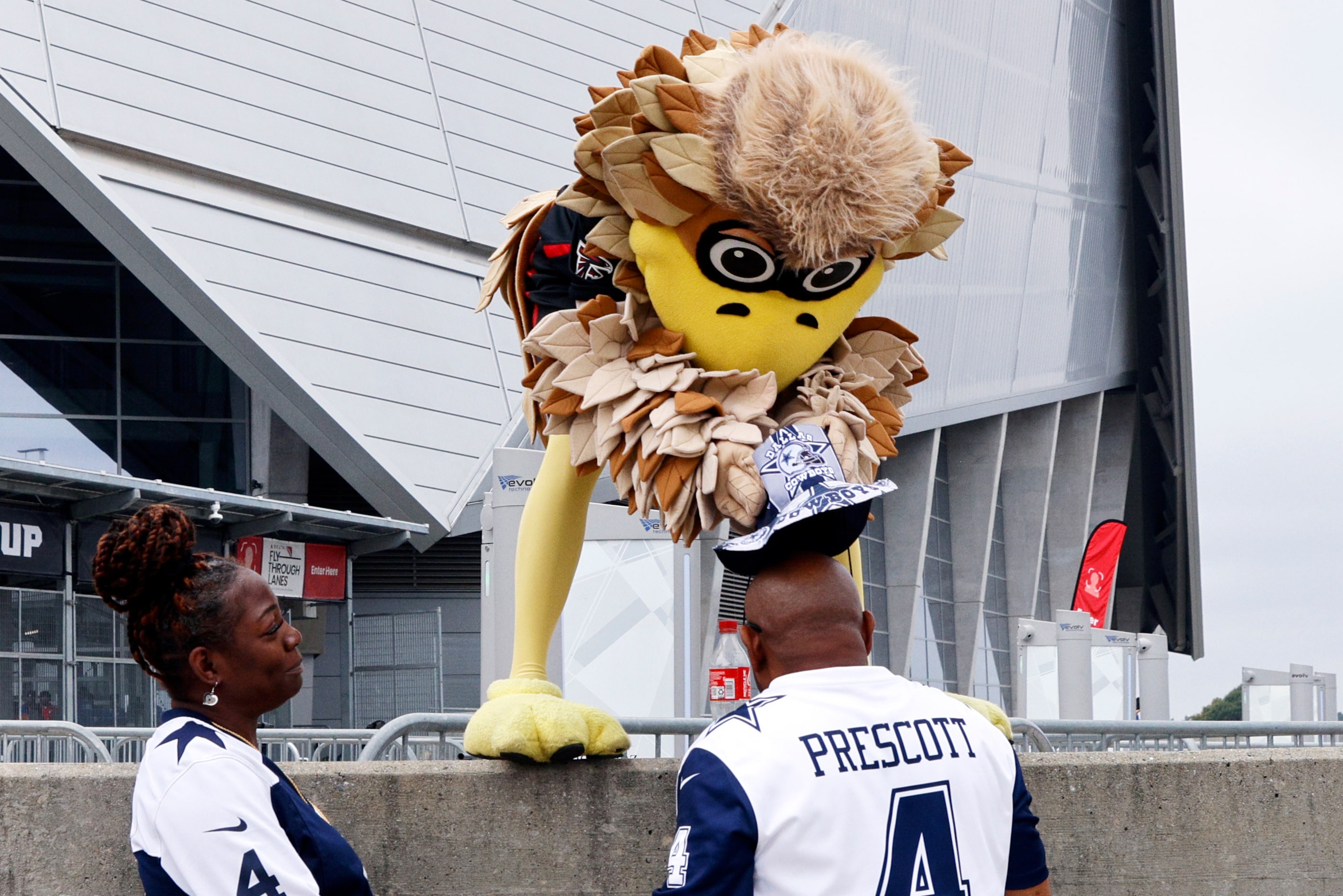 Atlanta Falcons mascot Freddie Falcon jokingly steals the hat of John Greer Sr. of...