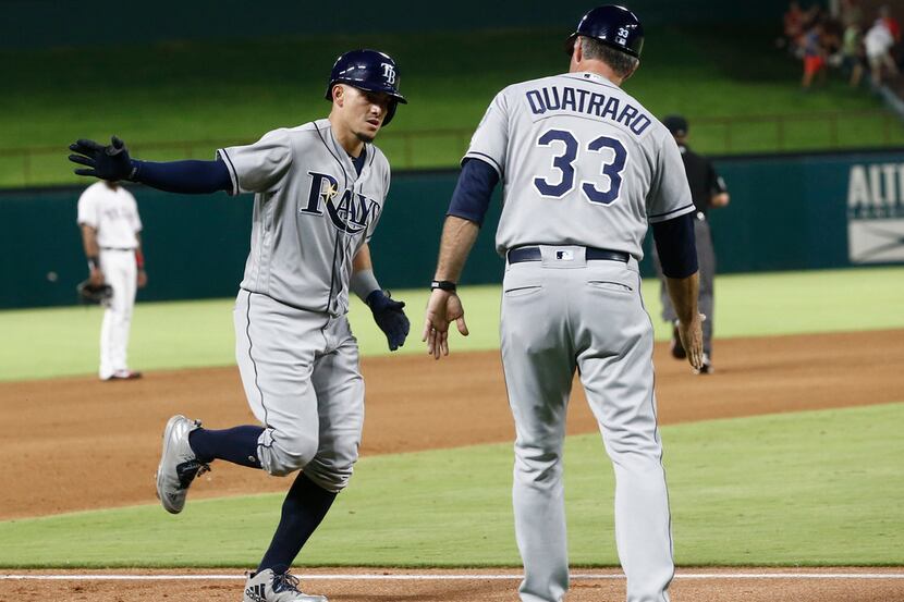 Tampa Bay Rays' Willy Adames, left, is congratulated by third base coach Matt Quatraro after...