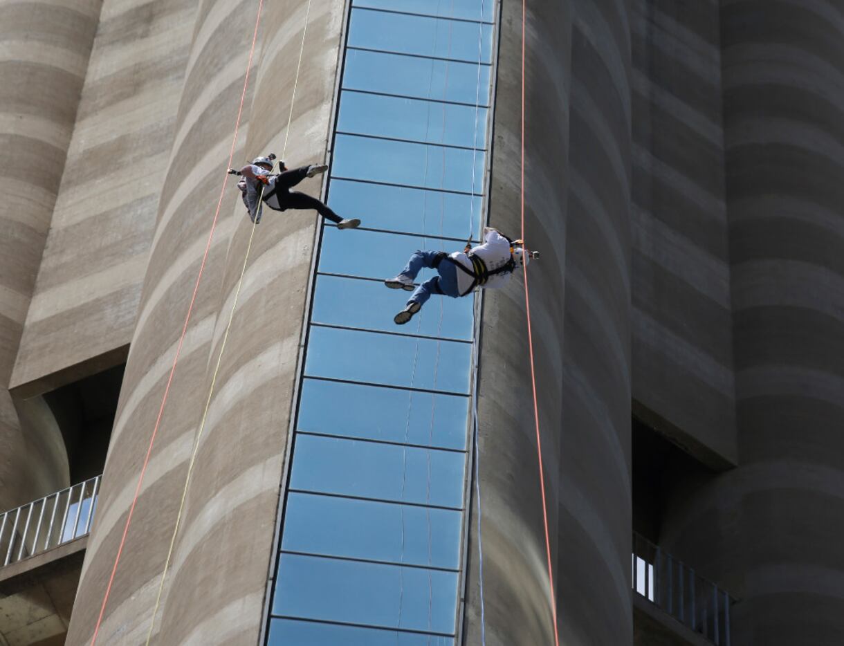 Blair McCurdy, left, and her dad, David Rogers, rappel off of Reunion Tower during the...