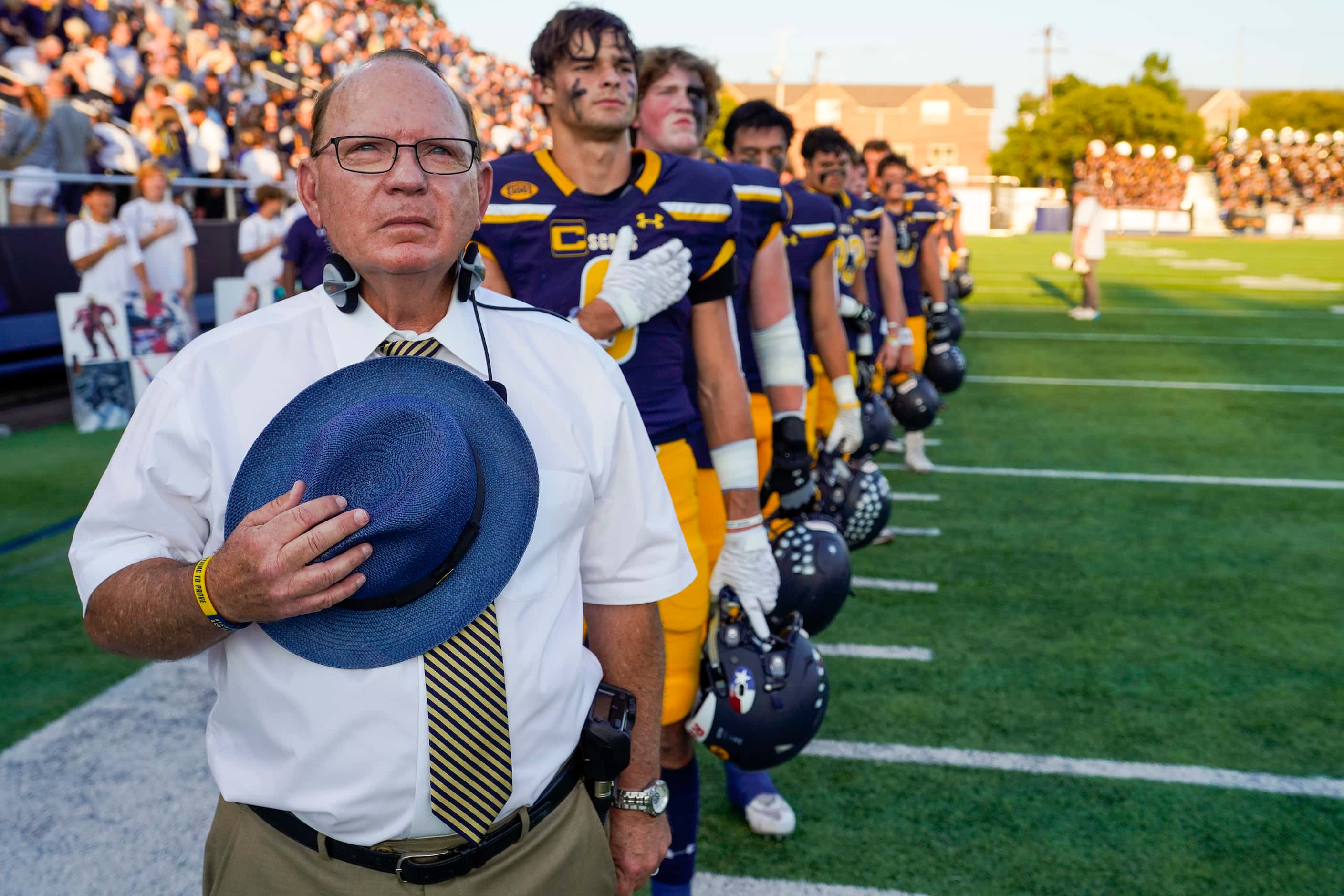 Highland Park head coach Randy Allen stands for the national anthem with his players before...